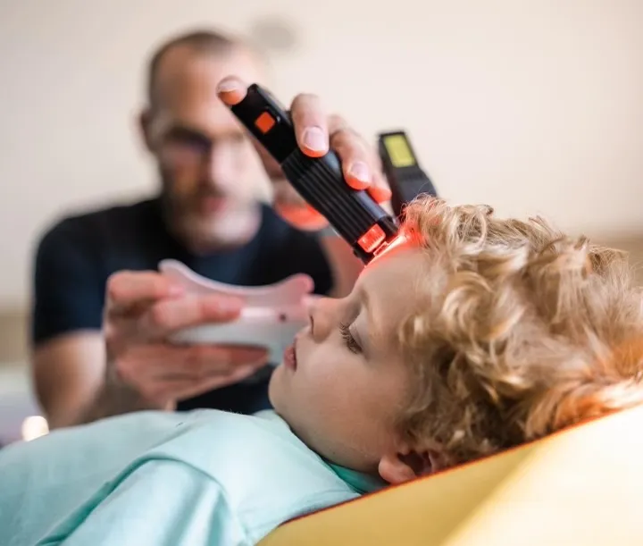 Dr. Kyle Daigle working with a young patient in his clinic